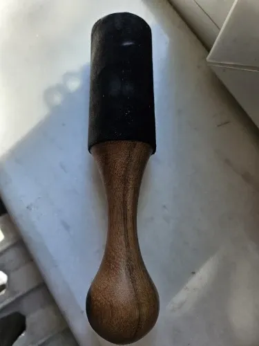 Verified buyer photo: leather-head mallet with shaped hardwood handle, photographed on a windowsill