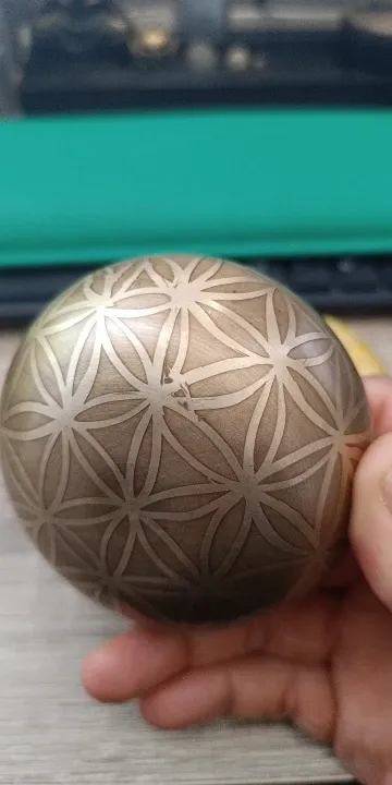 Verified buyer photo: close-up of the Flower of Life engraving on the underside of the set bowl, held in one hand